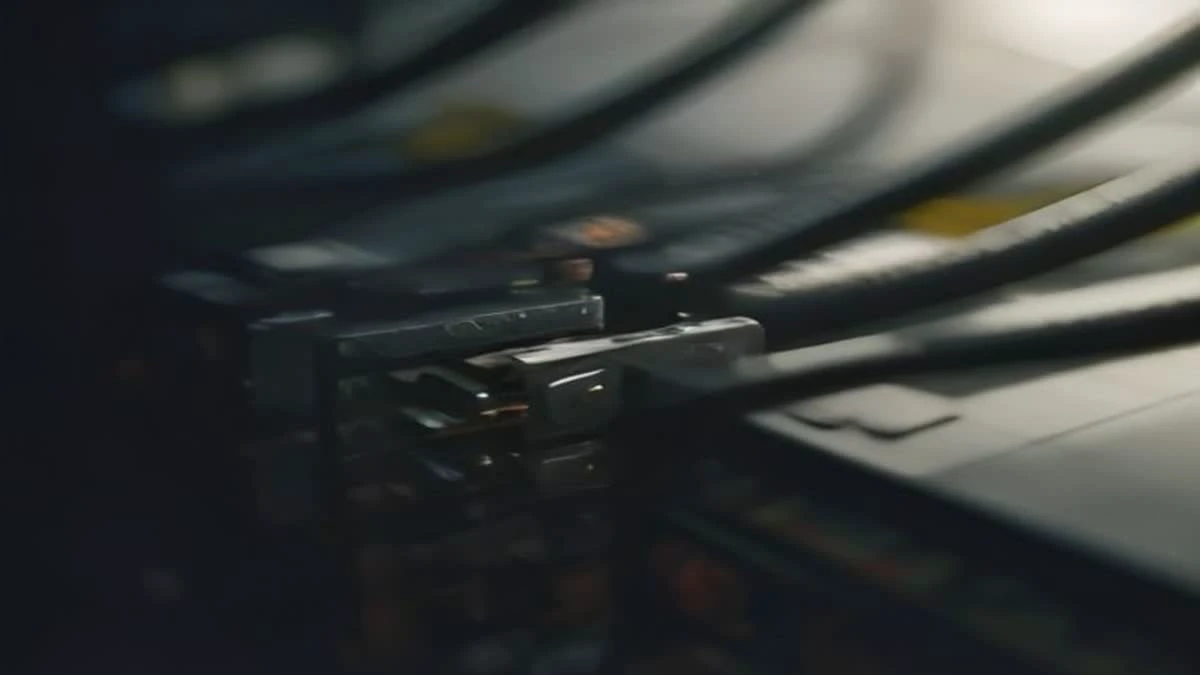 top-down flat lay of a technician plugging a network cable into a rack of equipment, hands in focus, soft morning light, used as the opening image